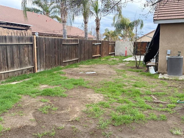 view of yard featuring a fenced backyard and central AC