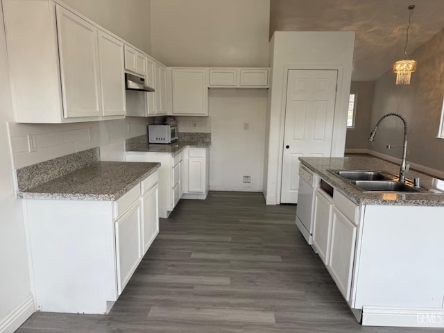 kitchen with white dishwasher, a sink, white cabinets, dark wood-style floors, and pendant lighting