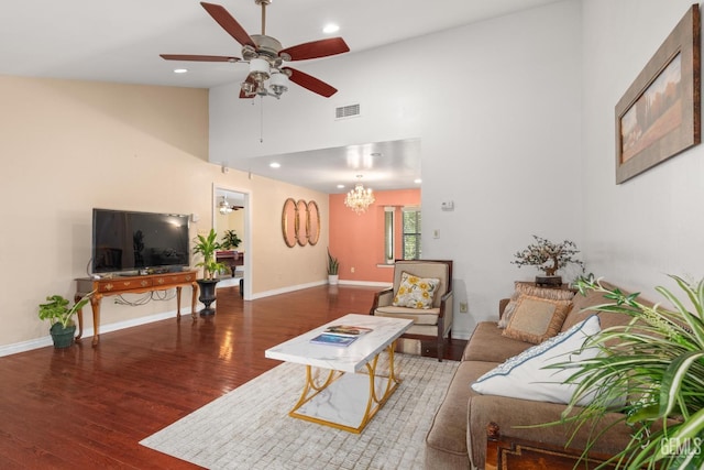 living room with ceiling fan with notable chandelier, high vaulted ceiling, and hardwood / wood-style floors