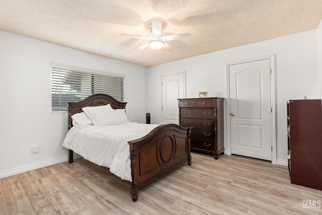 bedroom with ceiling fan, light hardwood / wood-style floors, and a textured ceiling