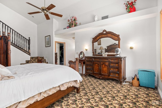 carpeted bedroom with lofted ceiling, a walk in closet, and ceiling fan