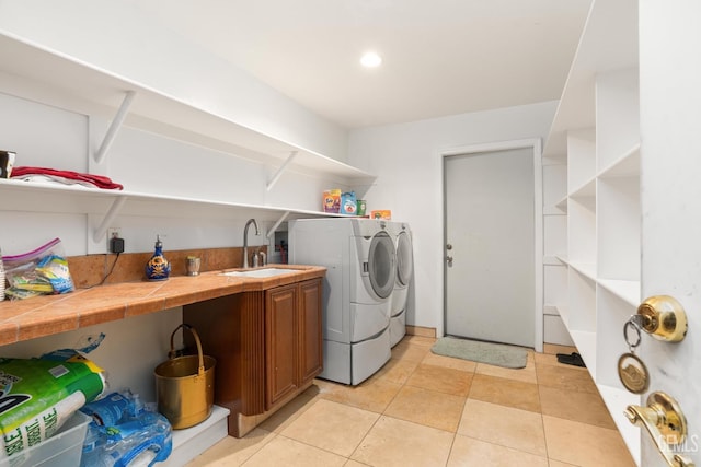 washroom with washing machine and dryer, sink, and light tile patterned floors