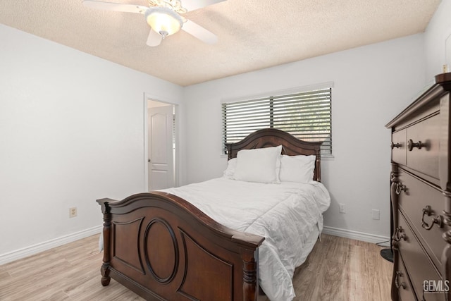 bedroom with ceiling fan, light hardwood / wood-style flooring, and a textured ceiling