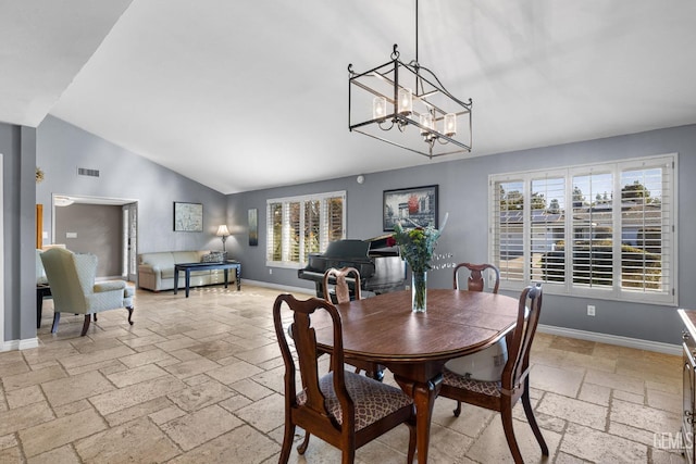 dining room featuring a wealth of natural light, lofted ceiling, and a notable chandelier