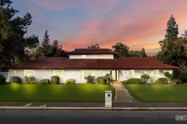 mediterranean / spanish-style home with a lawn