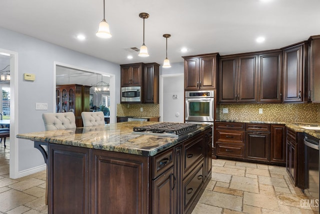 kitchen featuring pendant lighting, backsplash, a kitchen breakfast bar, dark brown cabinetry, and stainless steel appliances