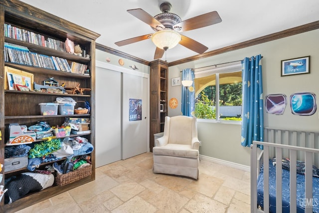 bedroom featuring a crib, a closet, ceiling fan, and ornamental molding