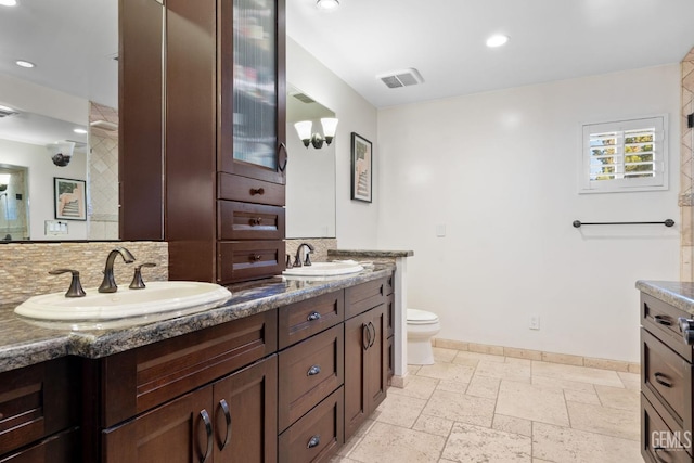 bathroom featuring decorative backsplash, vanity, and toilet