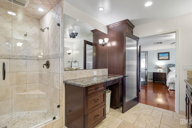 bathroom with vanity, a shower with shower door, and ornamental molding