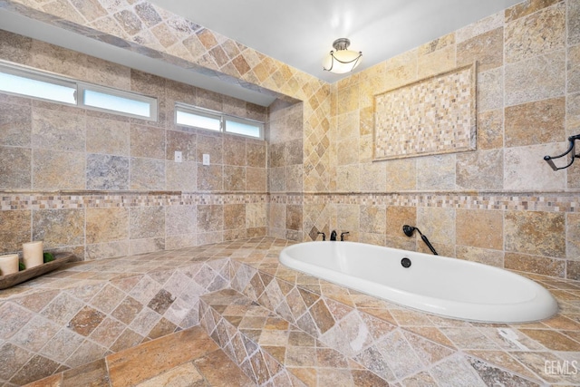 bathroom featuring a relaxing tiled tub