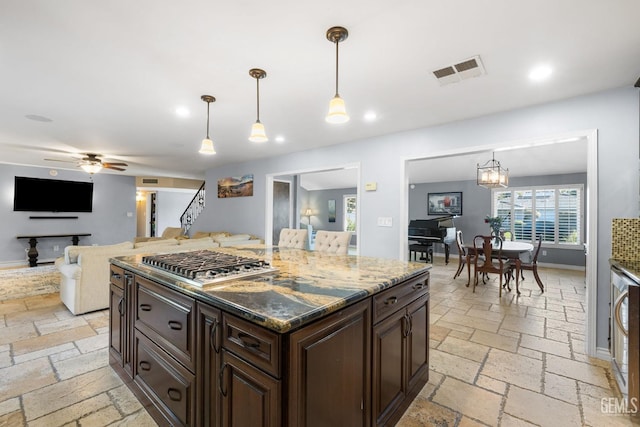 kitchen featuring dark brown cabinetry, ceiling fan with notable chandelier, decorative light fixtures, and stainless steel gas stovetop