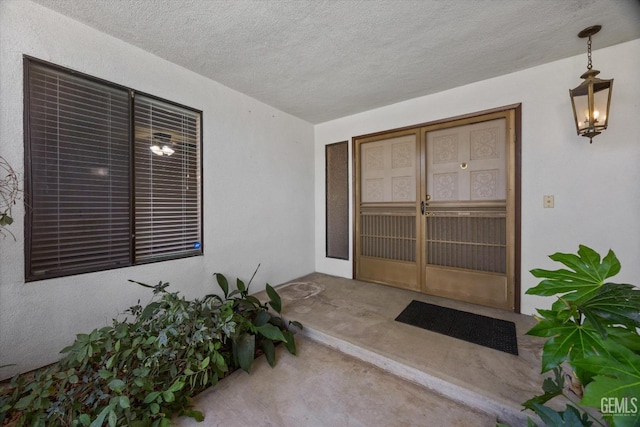 entrance to property with stucco siding and a patio