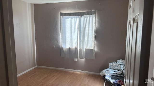 interior space with wood finished floors and baseboards