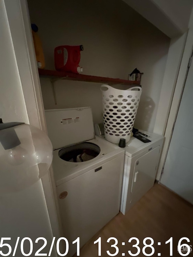 washroom featuring light wood-type flooring, laundry area, and separate washer and dryer