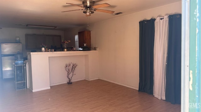 interior space with light wood-type flooring, visible vents, and a ceiling fan