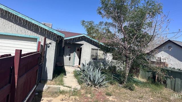 view of property exterior with fence and stucco siding