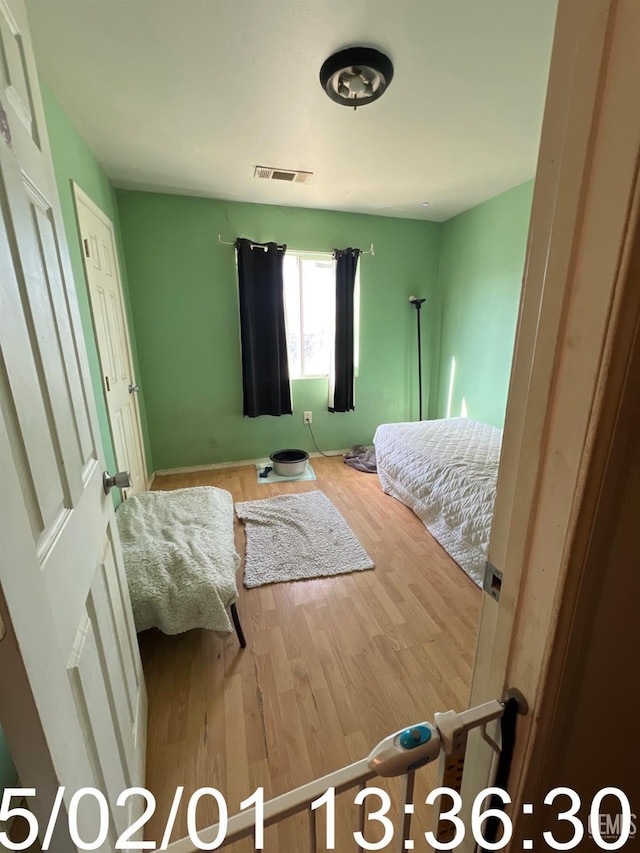 bedroom with visible vents and wood finished floors