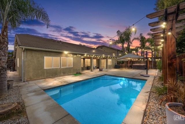 pool at dusk with a patio