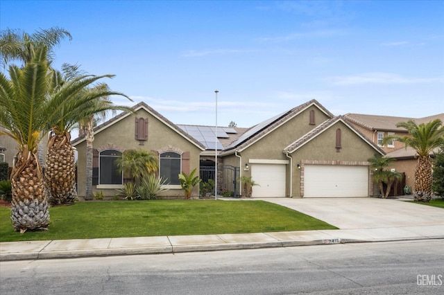 ranch-style home with solar panels, a garage, and a front yard