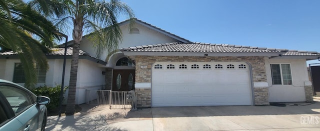 114 Clemson St, Shafter, CA 93263 - view of front of home with stone siding, stucco siding, an attached garage, and driveway