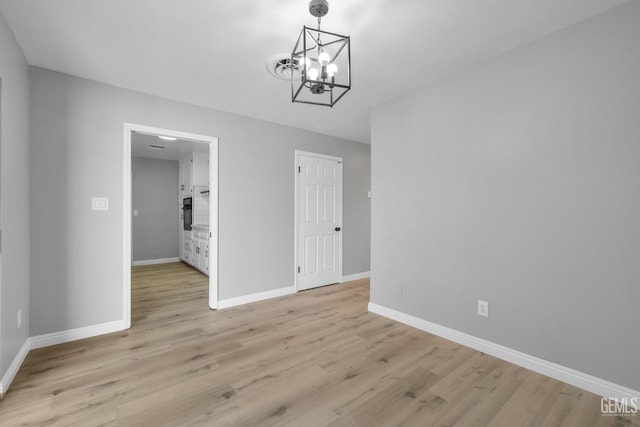 2848 Summit Cir, Bakersfield, CA 93306 - unfurnished dining area with light wood finished floors, baseboards, and a chandelier