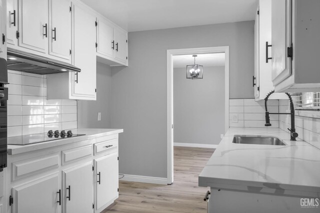 2848 Summit Cir, Bakersfield, CA 93306 - kitchen with a sink, under cabinet range hood, black electric cooktop, white cabinetry, and light wood-style flooring