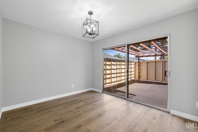 2848 Summit Cir, Bakersfield, CA 93306 - unfurnished room with wood finished floors, baseboards, and a chandelier