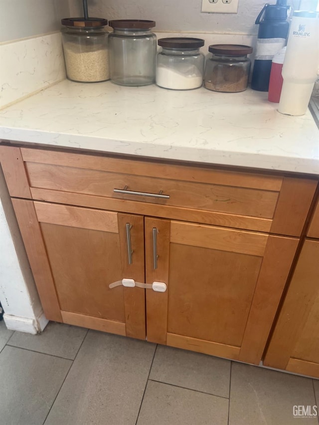 details with light stone counters and brown cabinets