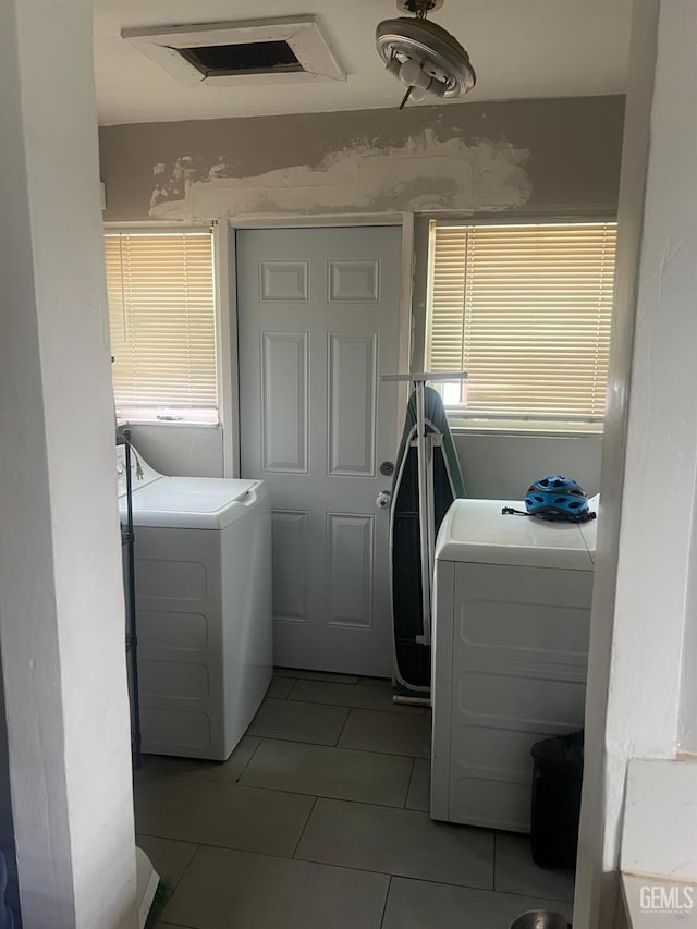 clothes washing area with laundry area, light tile patterned flooring, visible vents, and independent washer and dryer