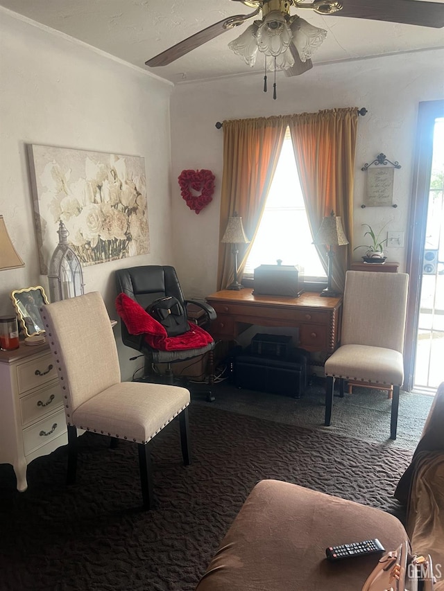 living area with a ceiling fan, a wealth of natural light, and carpet floors