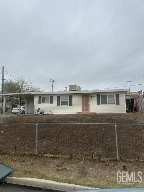 view of front of house with a fenced front yard, central air condition unit, and a carport