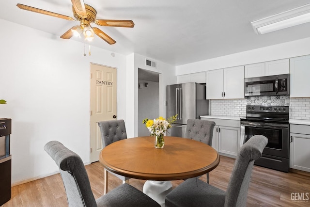 dining area with ceiling fan and light wood-type flooring