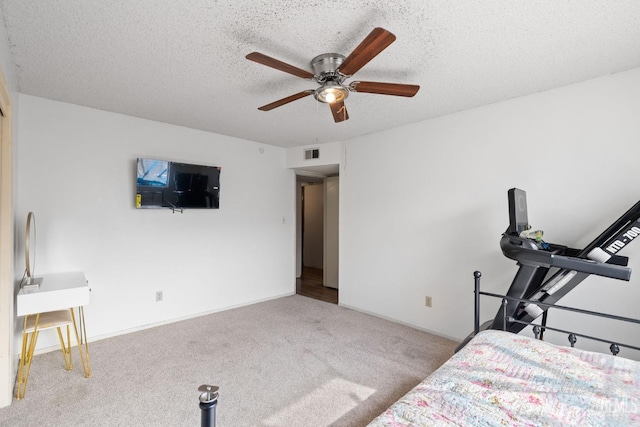 unfurnished bedroom with ceiling fan, light colored carpet, and a textured ceiling