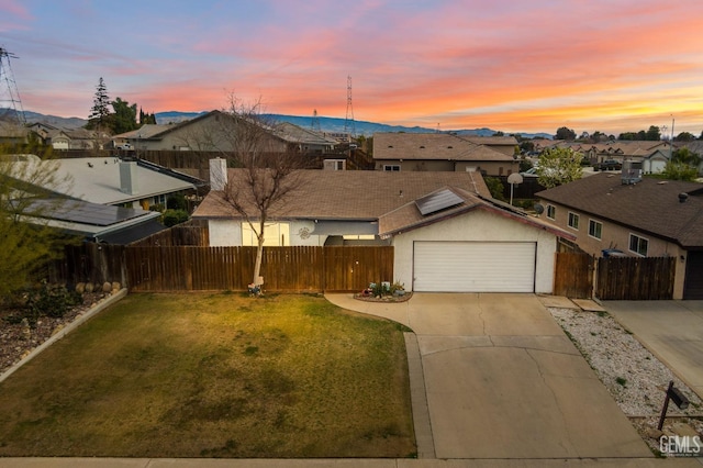 view of front of property featuring a garage and a lawn