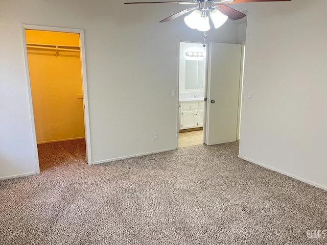 unfurnished bedroom with baseboards, a walk in closet, carpet, and a closet