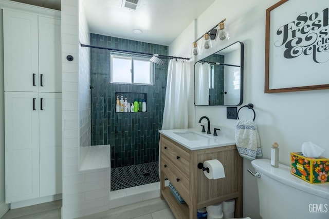 full bath with toilet, visible vents, tiled shower, and vanity