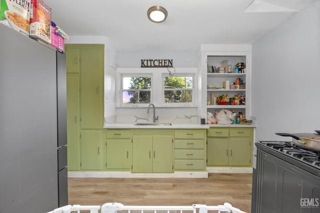 339 Ray St, Bakersfield, CA 93308 - kitchen with freestanding refrigerator, range with gas stovetop, light countertops, light wood-type flooring, and green cabinets