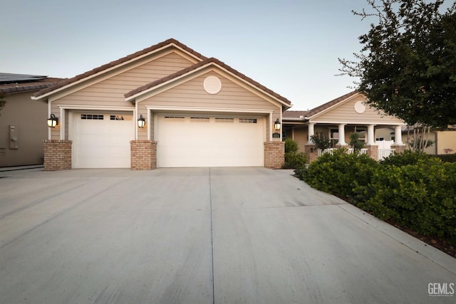 2624 Oakley St, Bakersfield, CA 93311 - craftsman-style house featuring an attached garage, driveway, brick siding, and a tiled roof