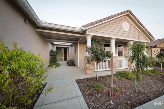 2624 Oakley St, Bakersfield, CA 93311 - entrance to property with a porch, stucco siding, and a tiled roof