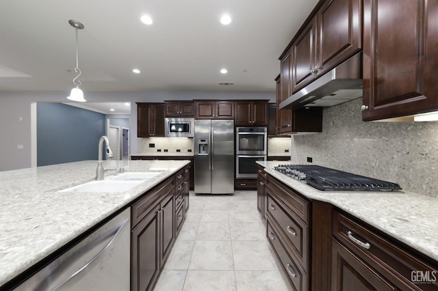2624 Oakley St, Bakersfield, CA 93311 - kitchen with appliances with stainless steel finishes, a sink, under cabinet range hood, tasteful backsplash, and pendant lighting