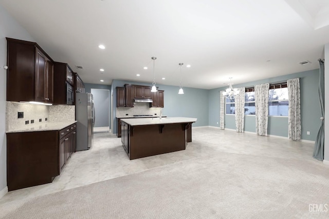 2624 Oakley St, Bakersfield, CA 93311 - kitchen with appliances with stainless steel finishes, a chandelier, light countertops, dark brown cabinetry, and an island with sink