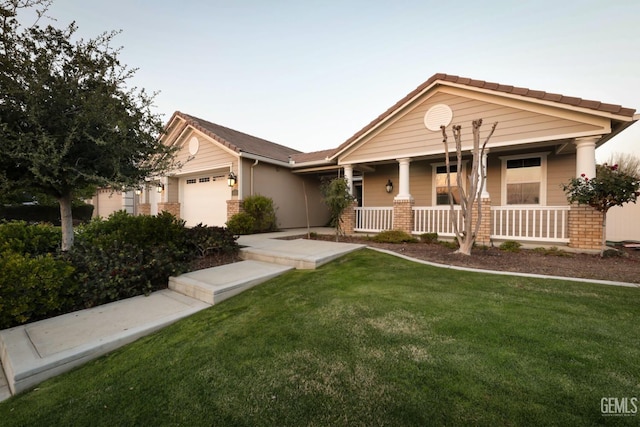 2624 Oakley St, Bakersfield, CA 93311 - view of front facade featuring an attached garage, covered porch, a front yard, a tile roof, and brick siding