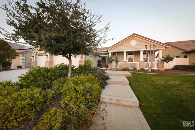 2624 Oakley St, Bakersfield, CA 93311 - view of front of home featuring covered porch, brick siding, and a front yard