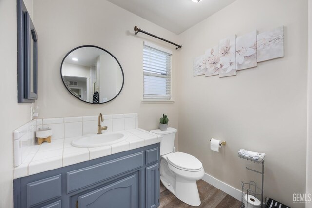 3404 Medallion Rose Ave, Bakersfield, CA 93313 - bathroom with wood finished floors, toilet, vanity, and baseboards