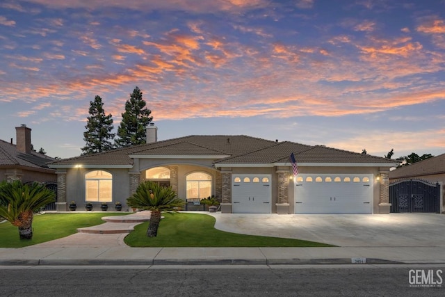 3404 Medallion Rose Ave, Bakersfield, CA 93313 - mediterranean / spanish house with an attached garage, stucco siding, a front lawn, and concrete driveway