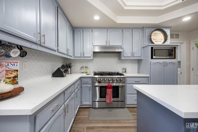 3404 Medallion Rose Ave, Bakersfield, CA 93313 - kitchen with appliances with stainless steel finishes, under cabinet range hood, dark wood finished floors, gray cabinets, and backsplash