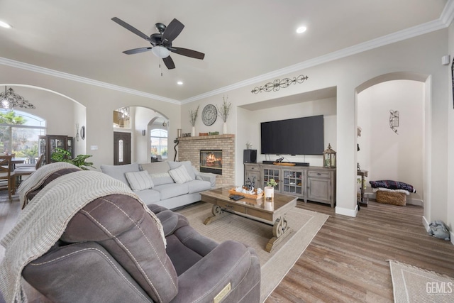 3404 Medallion Rose Ave, Bakersfield, CA 93313 - living room with arched walkways, plenty of natural light, wood finished floors, ornamental molding, and recessed lighting