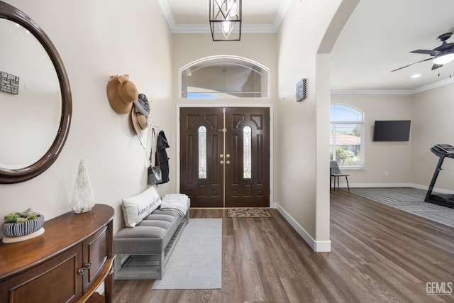 3404 Medallion Rose Ave, Bakersfield, CA 93313 - foyer featuring dark wood-type flooring, baseboards, ceiling fan, arched walkways, and crown molding
