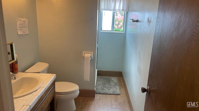 bathroom featuring vanity, hardwood / wood-style flooring, and toilet