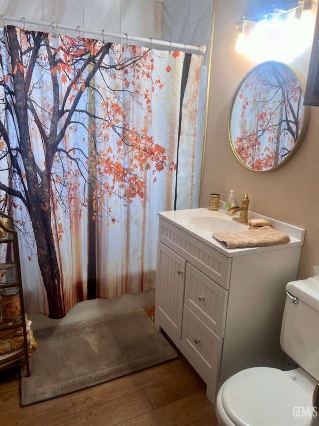 bathroom featuring hardwood / wood-style floors, vanity, toilet, and curtained shower